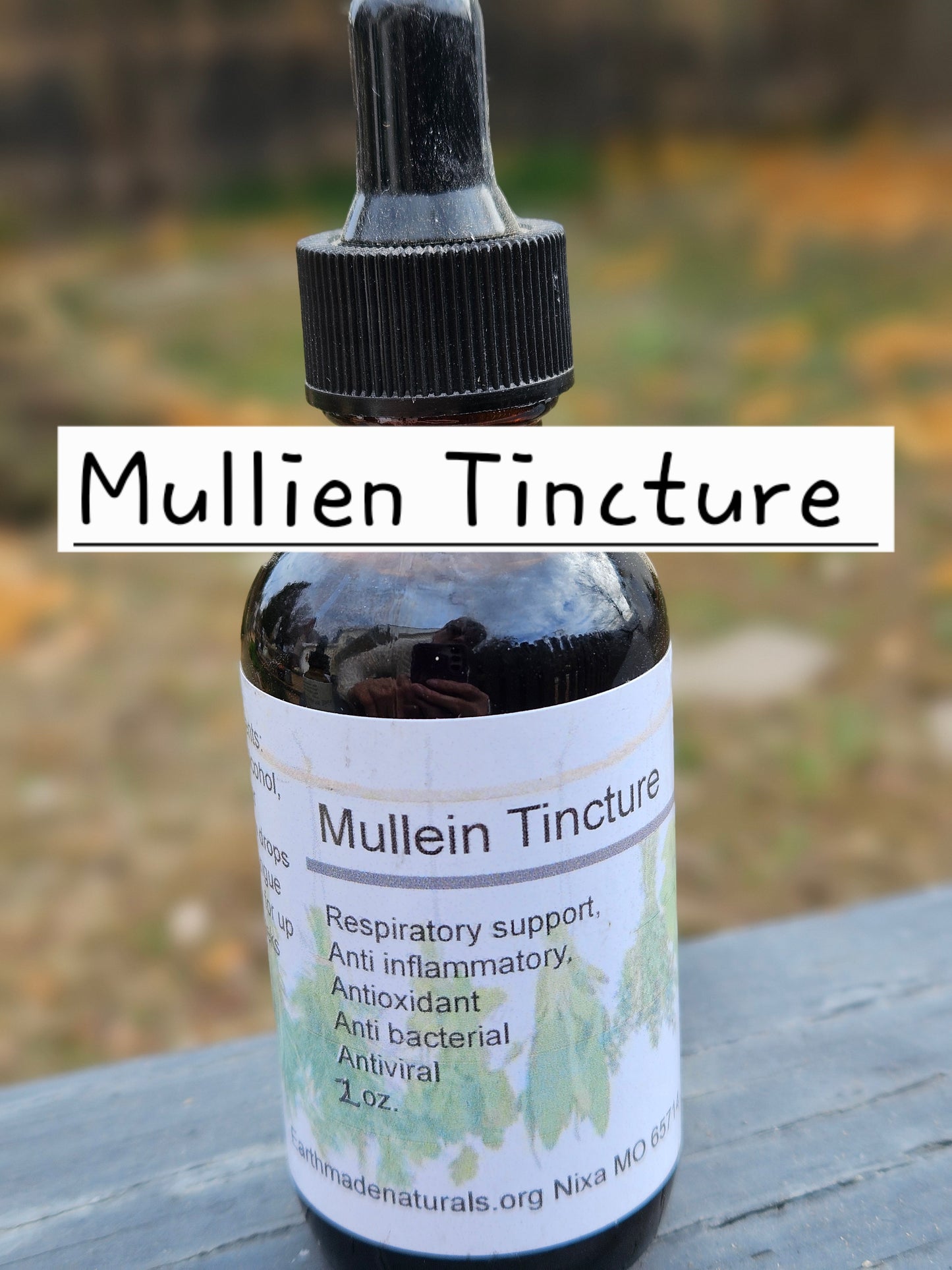 Bottle of Mullien Tincture with a dropper on a wooden surface with a blurred natural background.