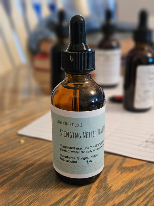 Bottle of Stinging Nettle Tincture on a wooden surface with blurred background