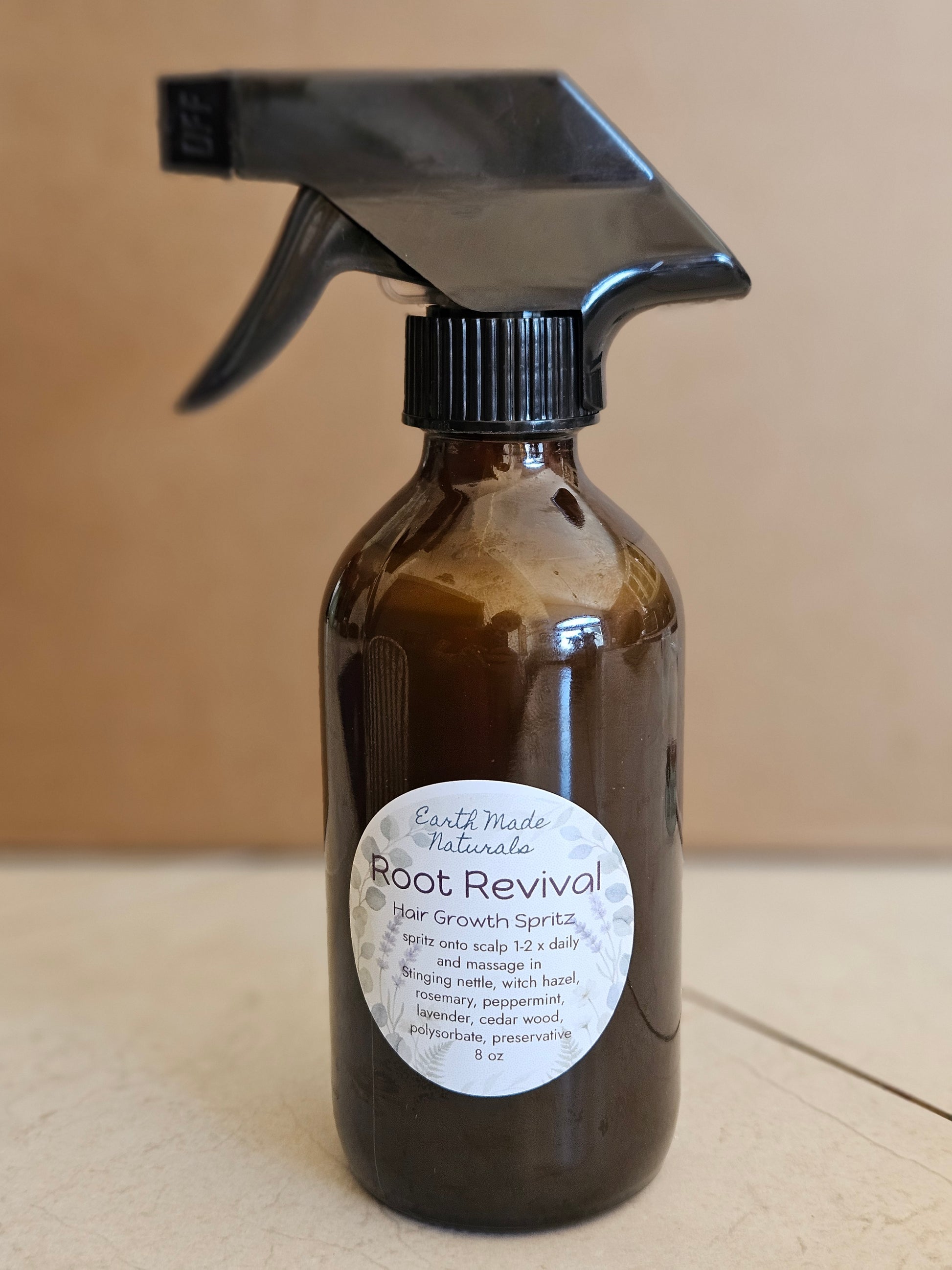 Brown spray bottle with a label on a beige background