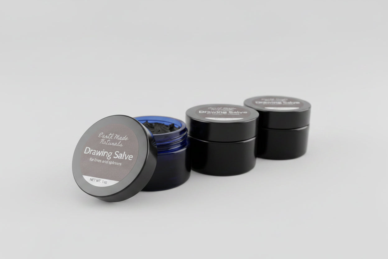 Two containers of Earth Made Naturals Drawing Salve on a tiled floor.