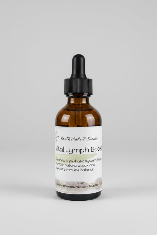 A 2 oz amber glass dropper bottle of Vital Lymph Booster by Earth Made Naturals, resting on a dark countertop with a blurred kitchen background.