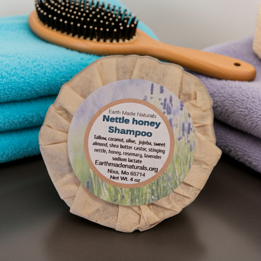 Bar of Earth Made Naturals Nettle honey Shampoo with a brush and towels in the background