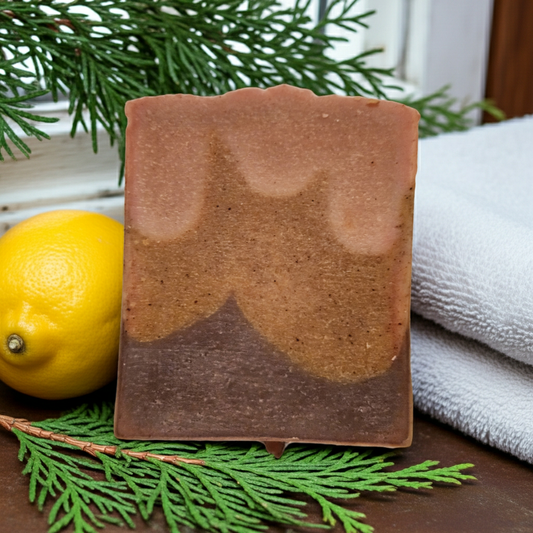Bar of soap with a lemon and greenery on a wooden surface