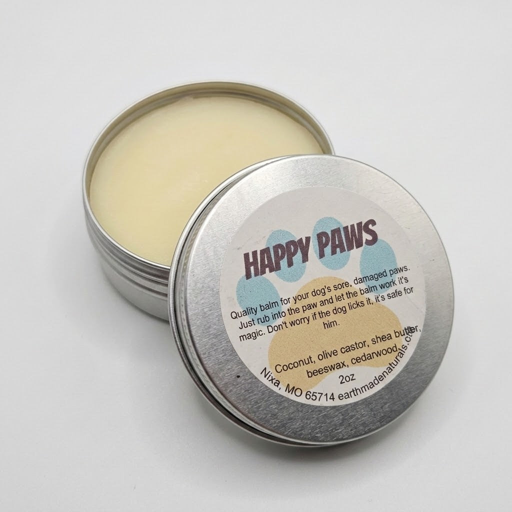 An open round silver tin of Happy Paws dog balm showing the pale yellow balm inside, with the lid placed in front displaying the product label.